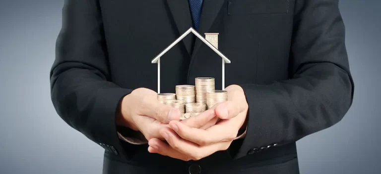Property developer | Person holding a model of a house.