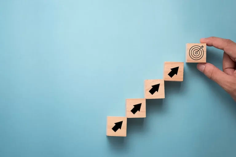 The benefits of a business plan | Wooden blocks with arrows arranged in an upwards staircase.
