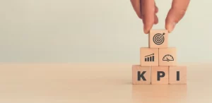 KPI tracking | Person stacking wooden cubes with KPI written on them.