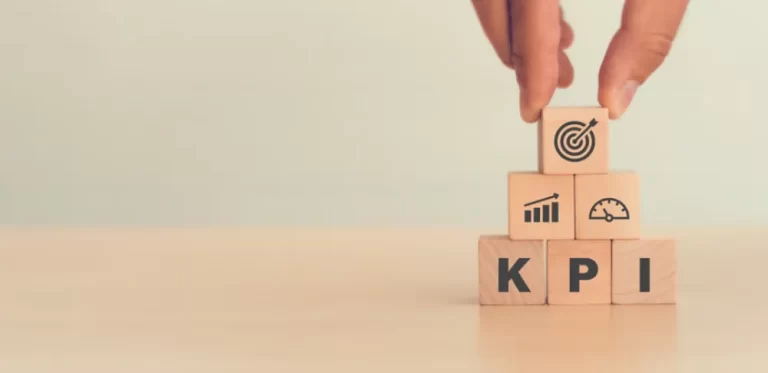 KPI tracking | Person stacking wooden cubes with KPI written on them.