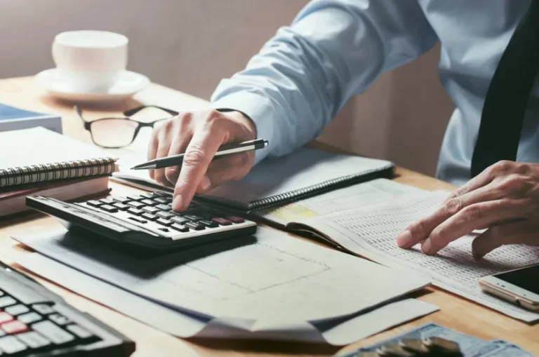 Palmers Accounting | Person typing on a calculator on the desk.
