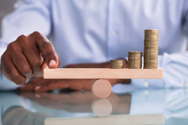 Man balancing coins and a finger on a scale